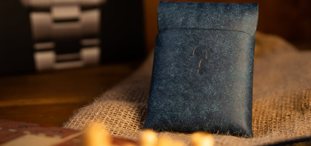 Dark blue pueblo leather wallet pouch on a textured surface with blurred background