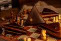 Brown leather triangle-shaped item on a chessboard with chess pieces.