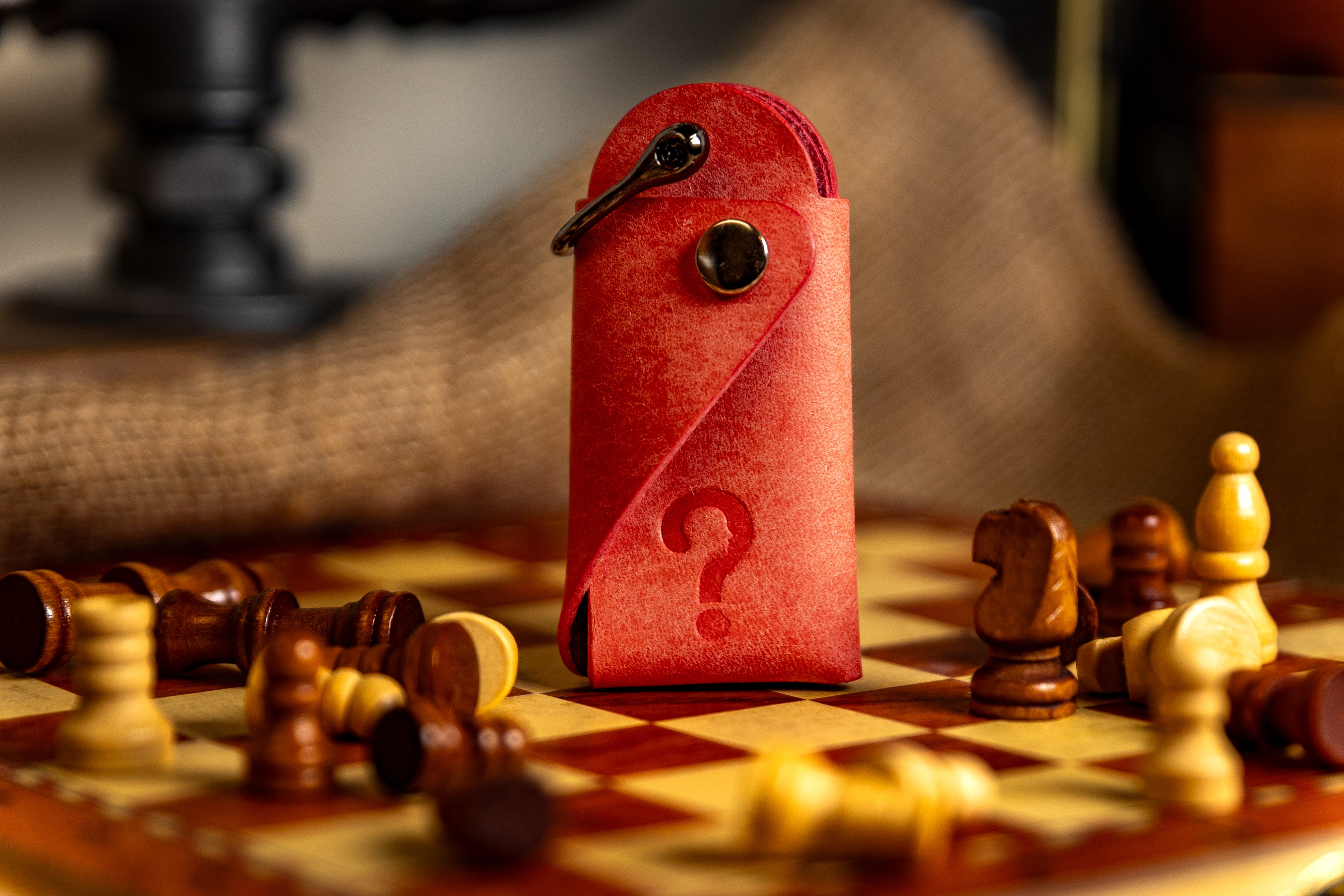 pink leather key case with a question mark on a chessboard