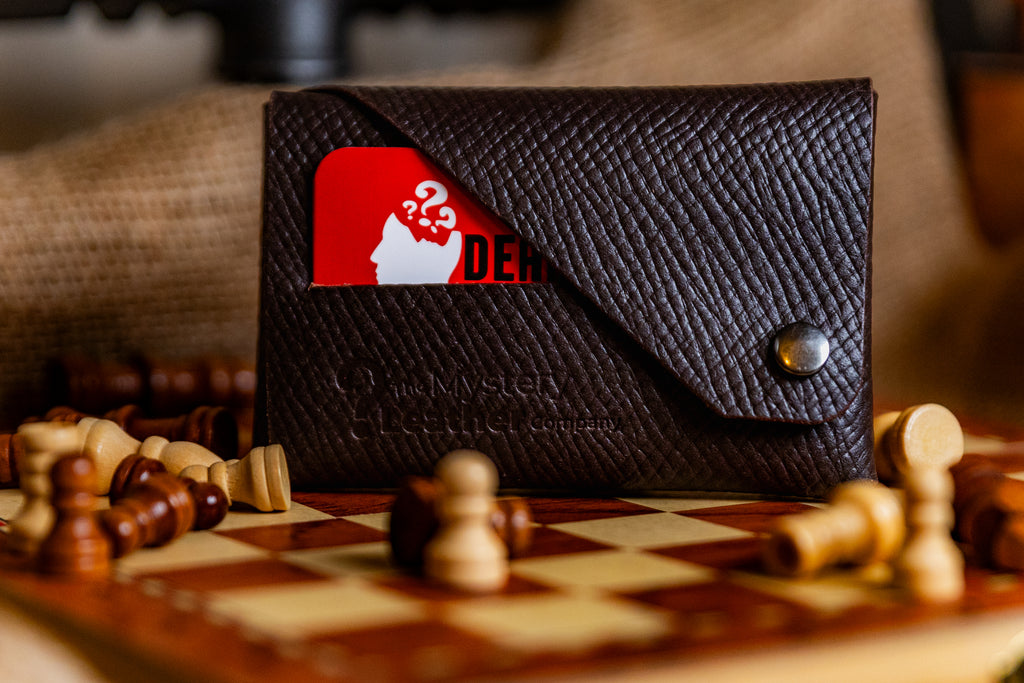 Black leather wallet with a logo on a chessboard