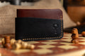 Black and brown leather wallet on a chessboard