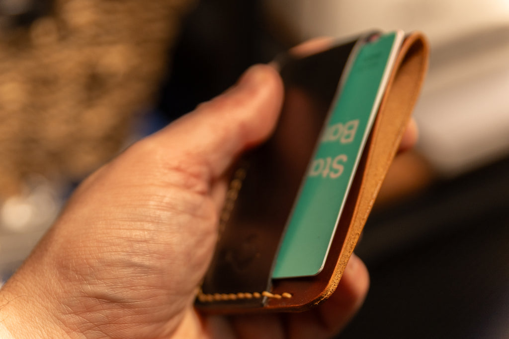 Hand holding a leather wallet with a blurred background