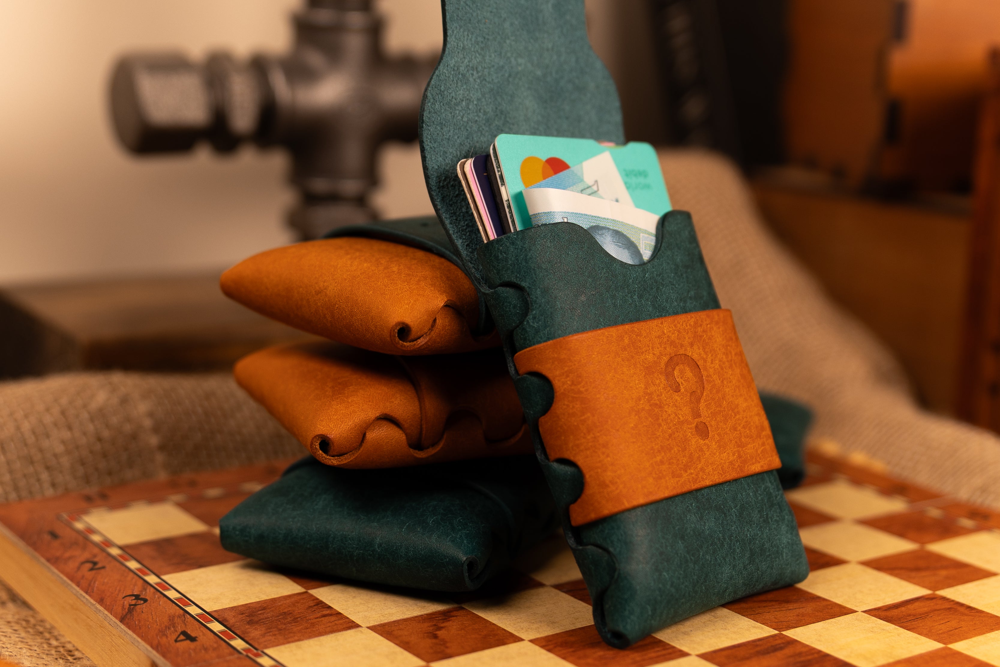 Green and brown pueblo leather wallet with cards on a checkered surface