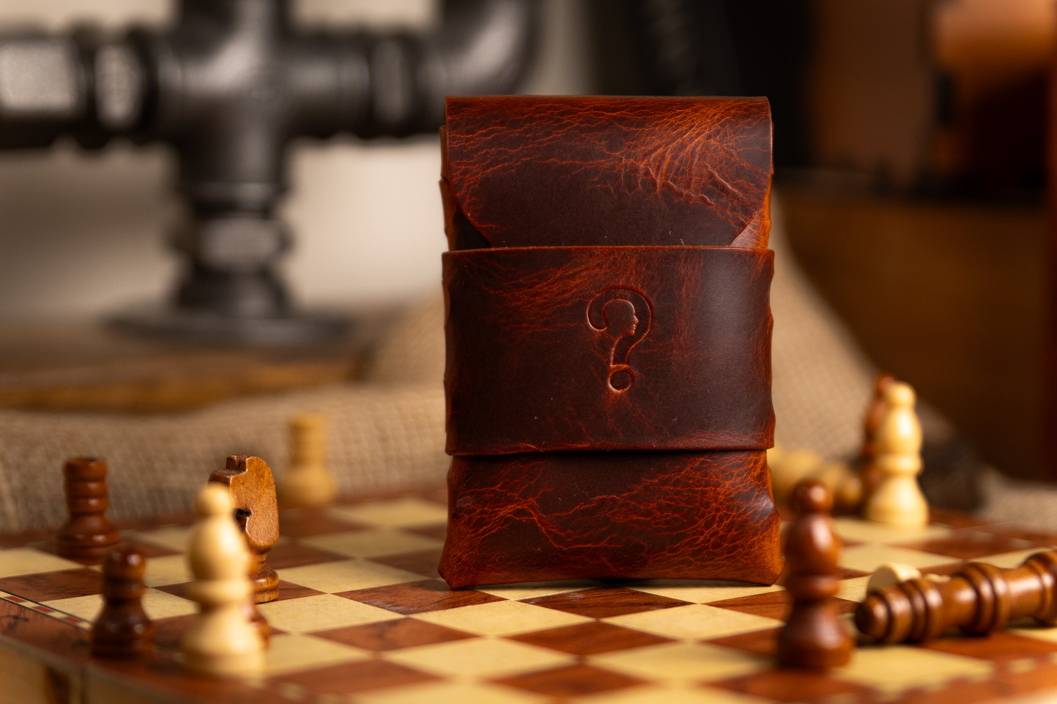Brown leather wallet with a question mark on a chessboard