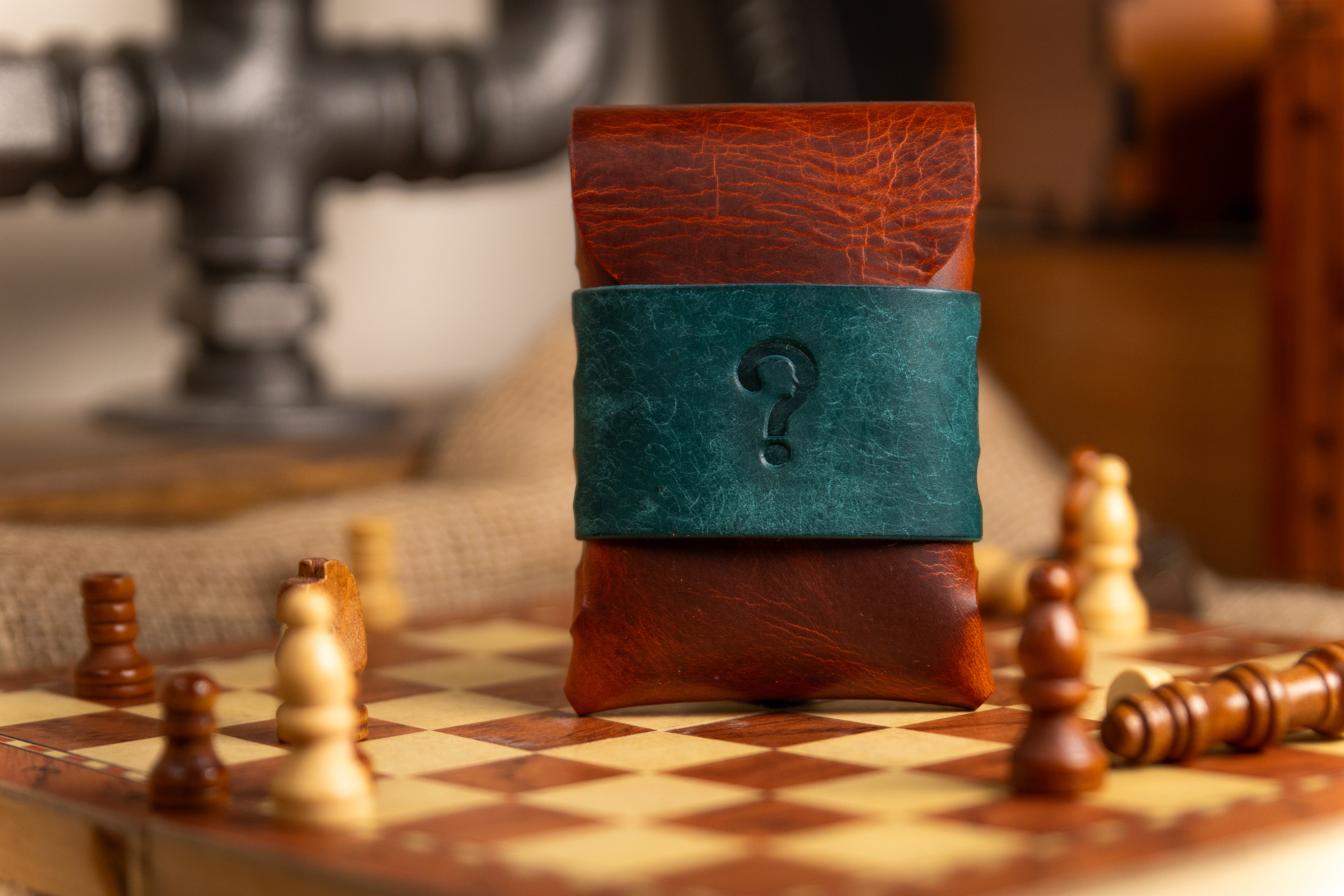 wax leather wallet stacked on a chessboard with chess pieces around