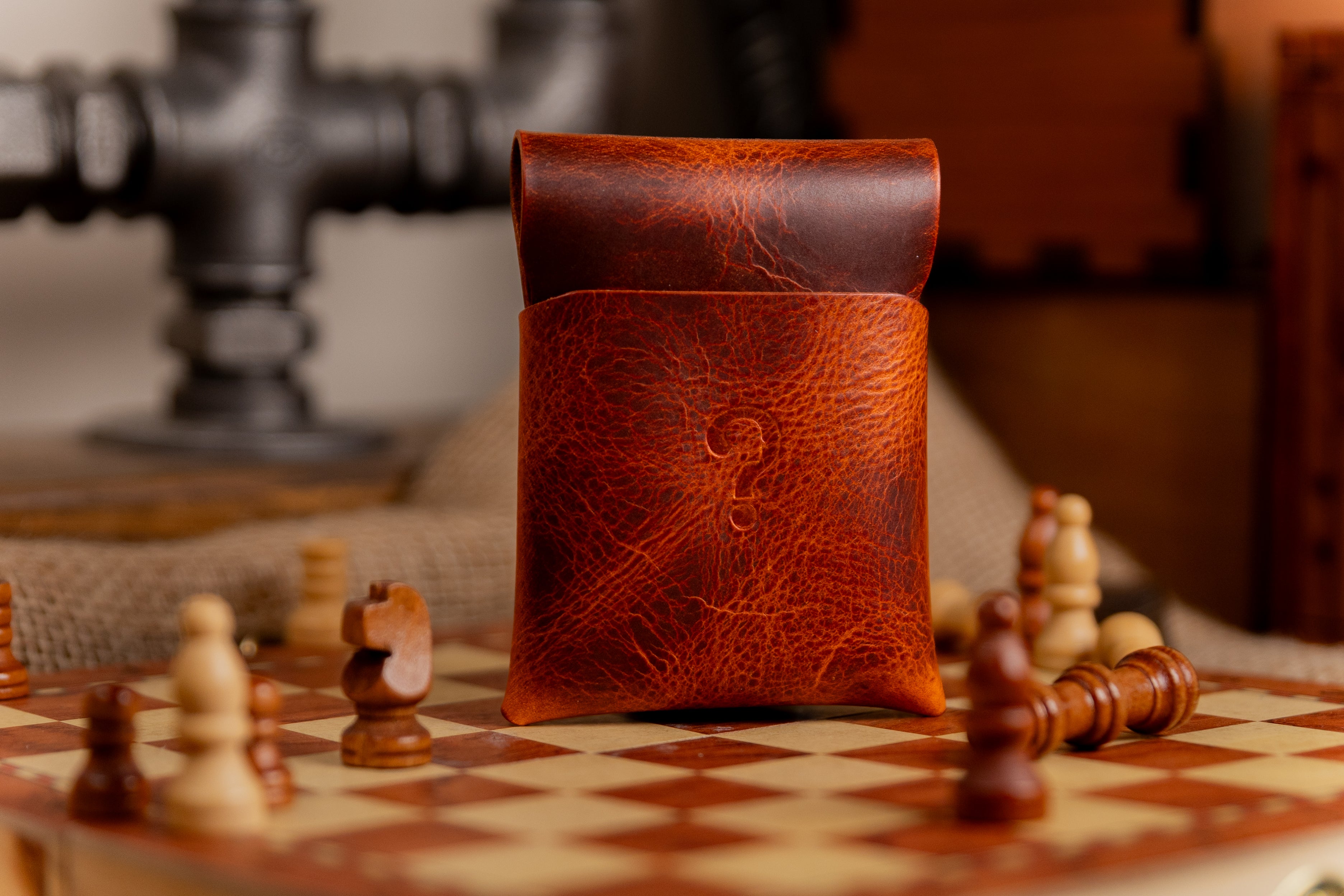 Brown leather wax leather wallet pouch on a chessboard with chess pieces