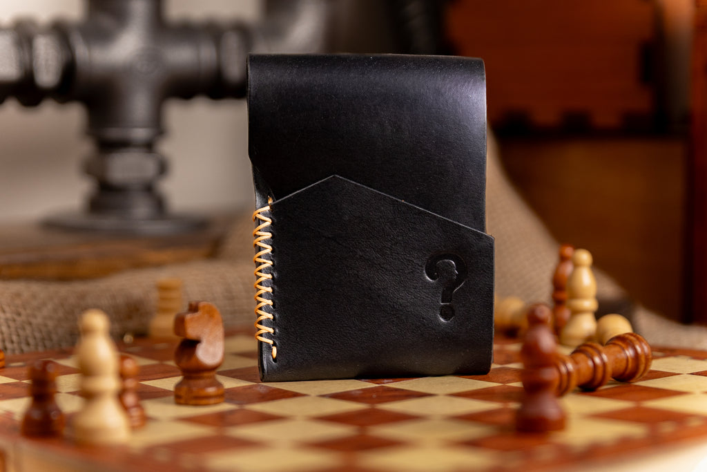 Black leather wallet with a question mark design on a chessboard
