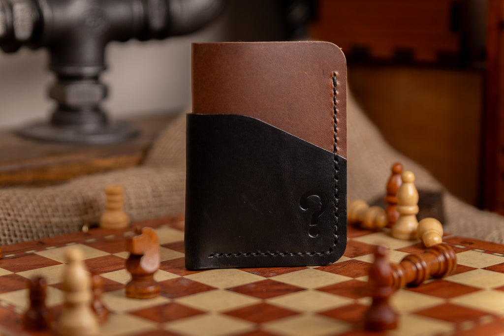 Two-tone leather wallet on a chessboard with chess pieces.