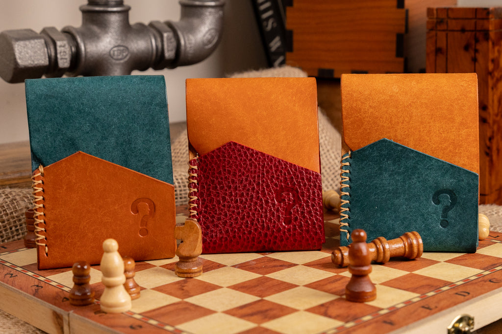 Three  pueblo leather card holders with question marks on a chessboard